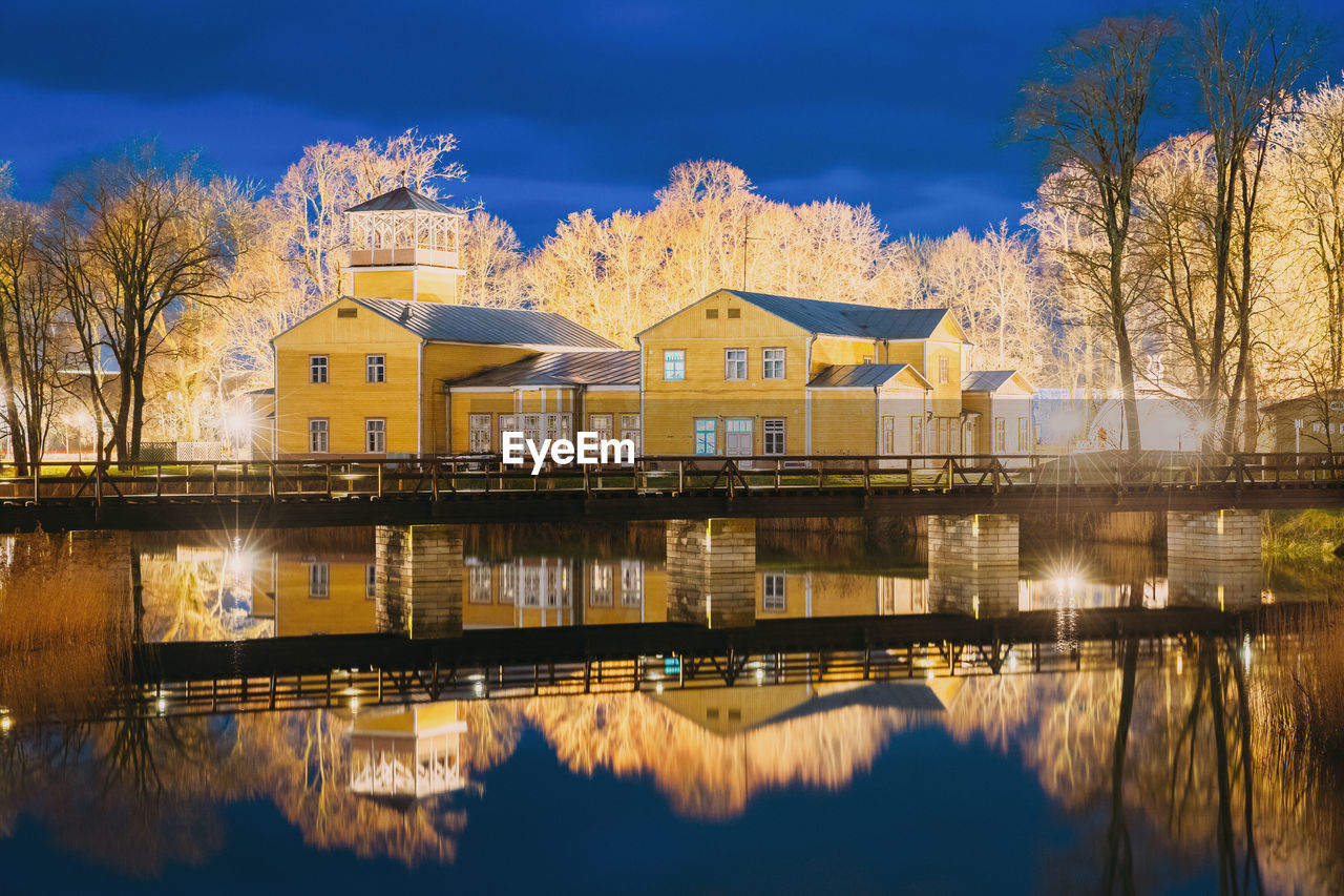 reflection of buildings in lake against sky