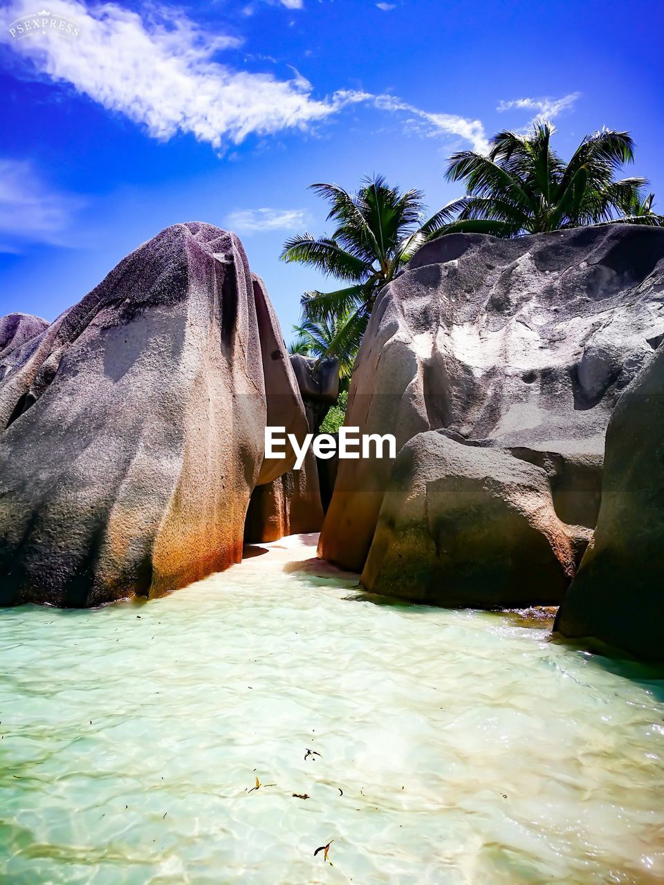 Scenic view of rocks by sea against sky