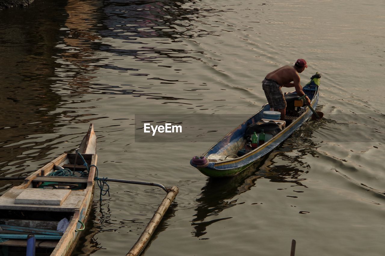 HIGH ANGLE VIEW OF MAN PHOTOGRAPHING BOAT IN LAKE