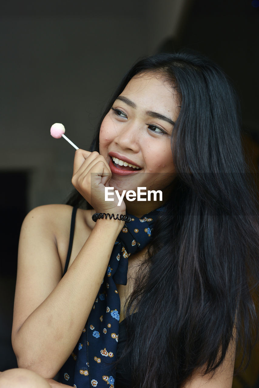 Close-up of young woman holding lollipop