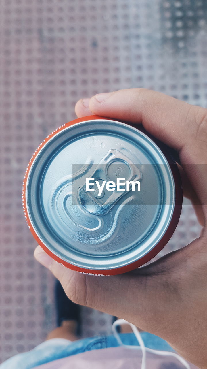 Close-up of man holding can outdoors