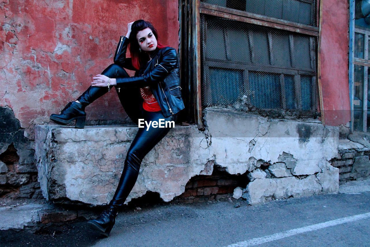 Portrait of punk woman by abandoned building