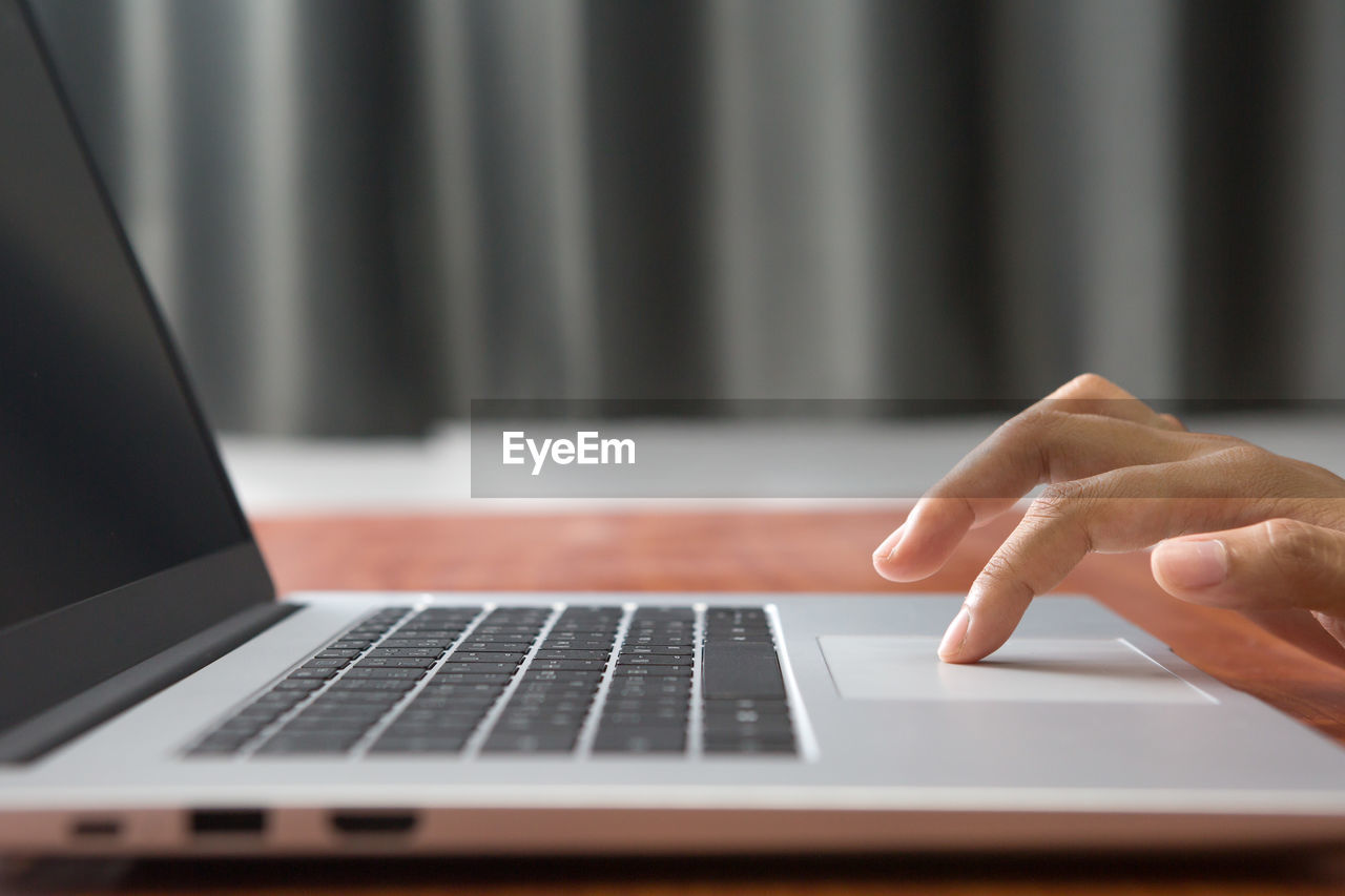 midsection of woman using laptop on table