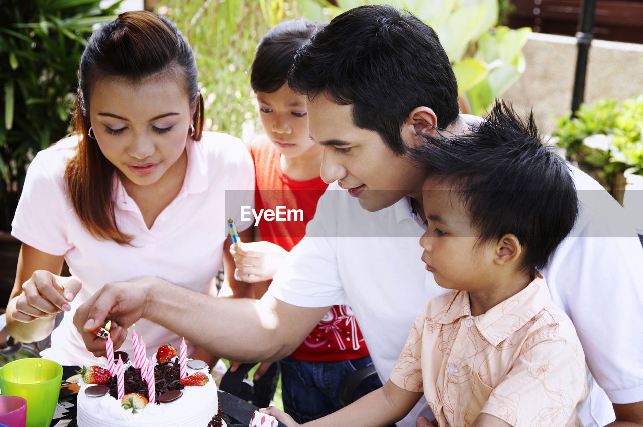 Family celebrating birthday in lawn