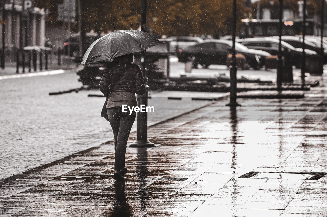 Man walking on wet street during rainy season