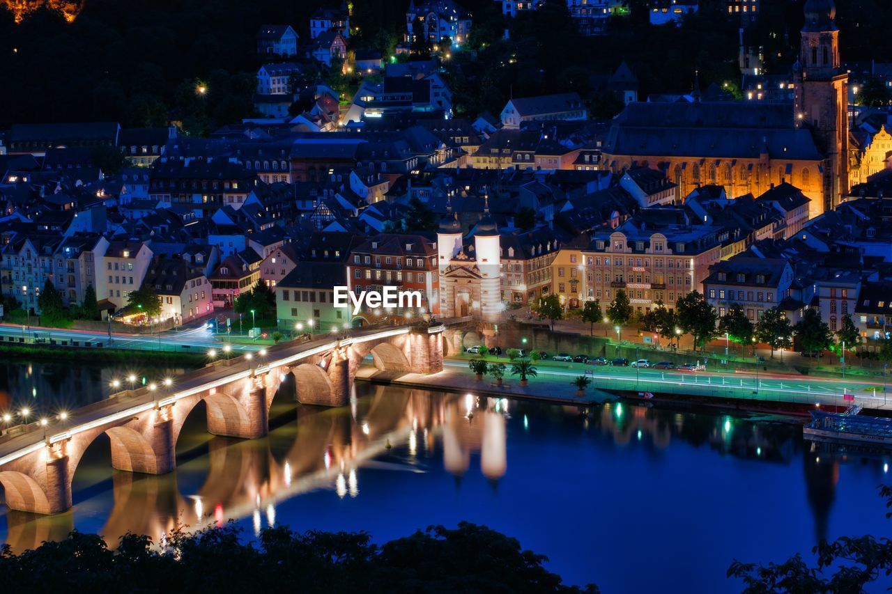 Illuminated bridge over river at night