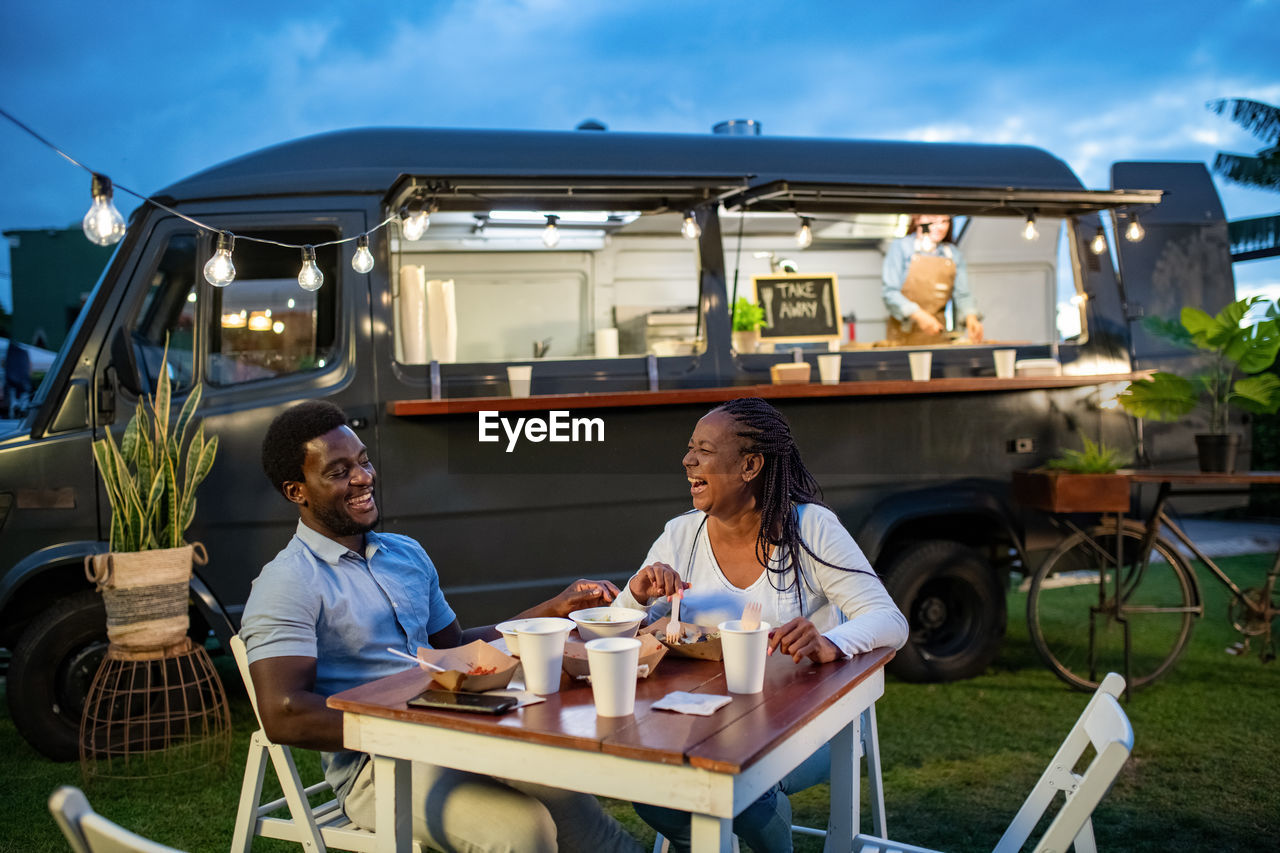 Smiling couple having street food