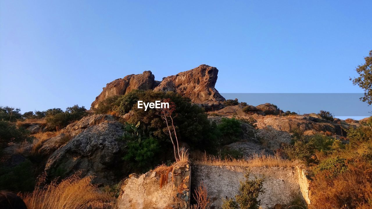 Rock formation on mountain against clear sky