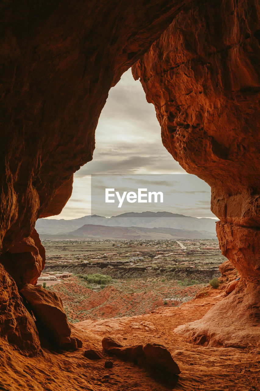 Looking out at the town of st. george utah from a large cave entrance