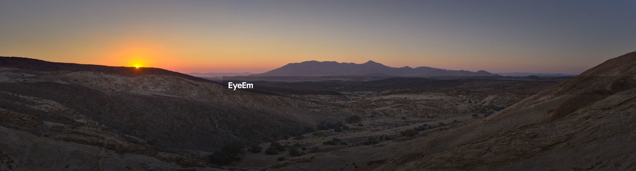 Scenic view of mountains against clear sky during sunset