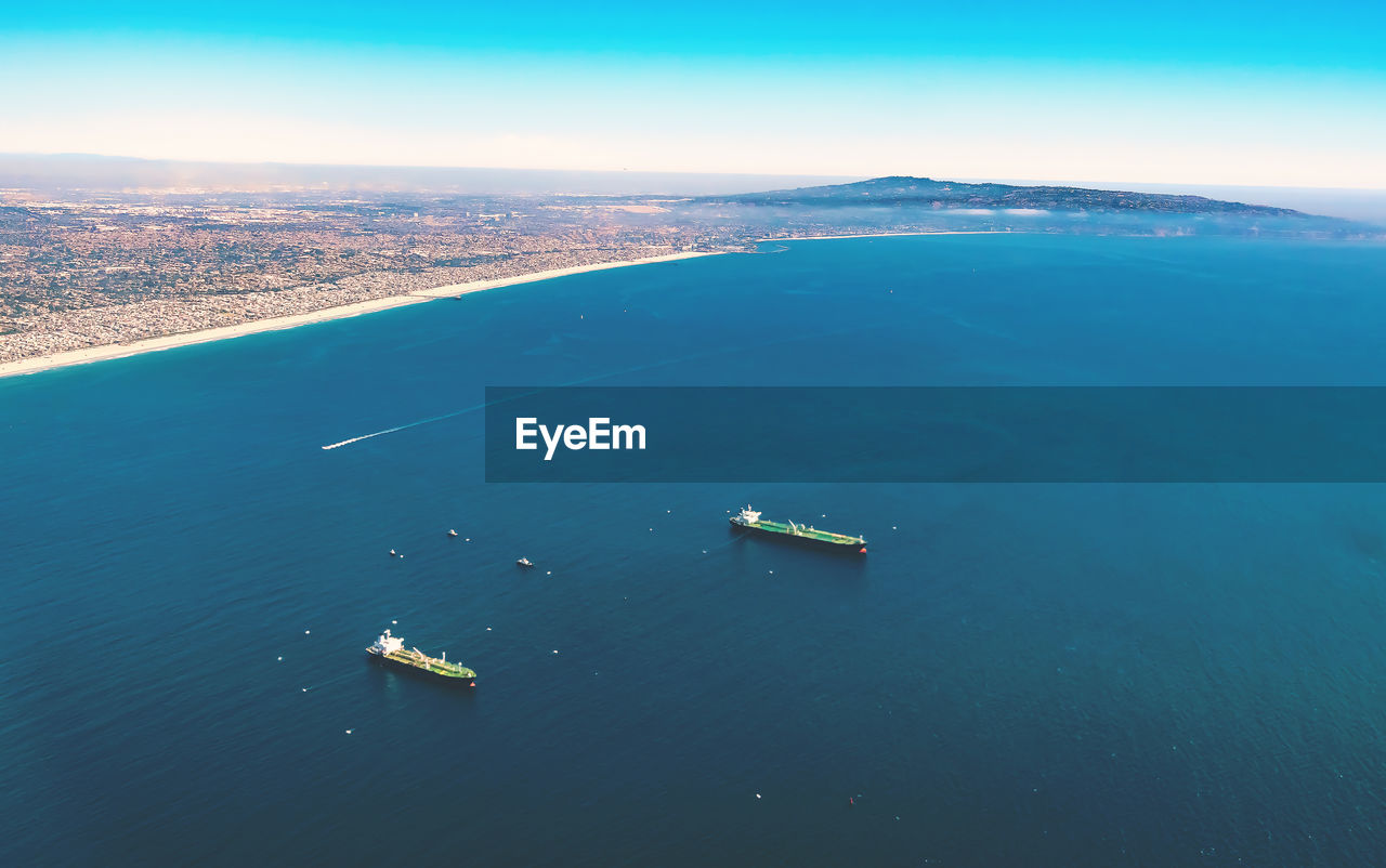 Aerial view of container ship in sea against sky