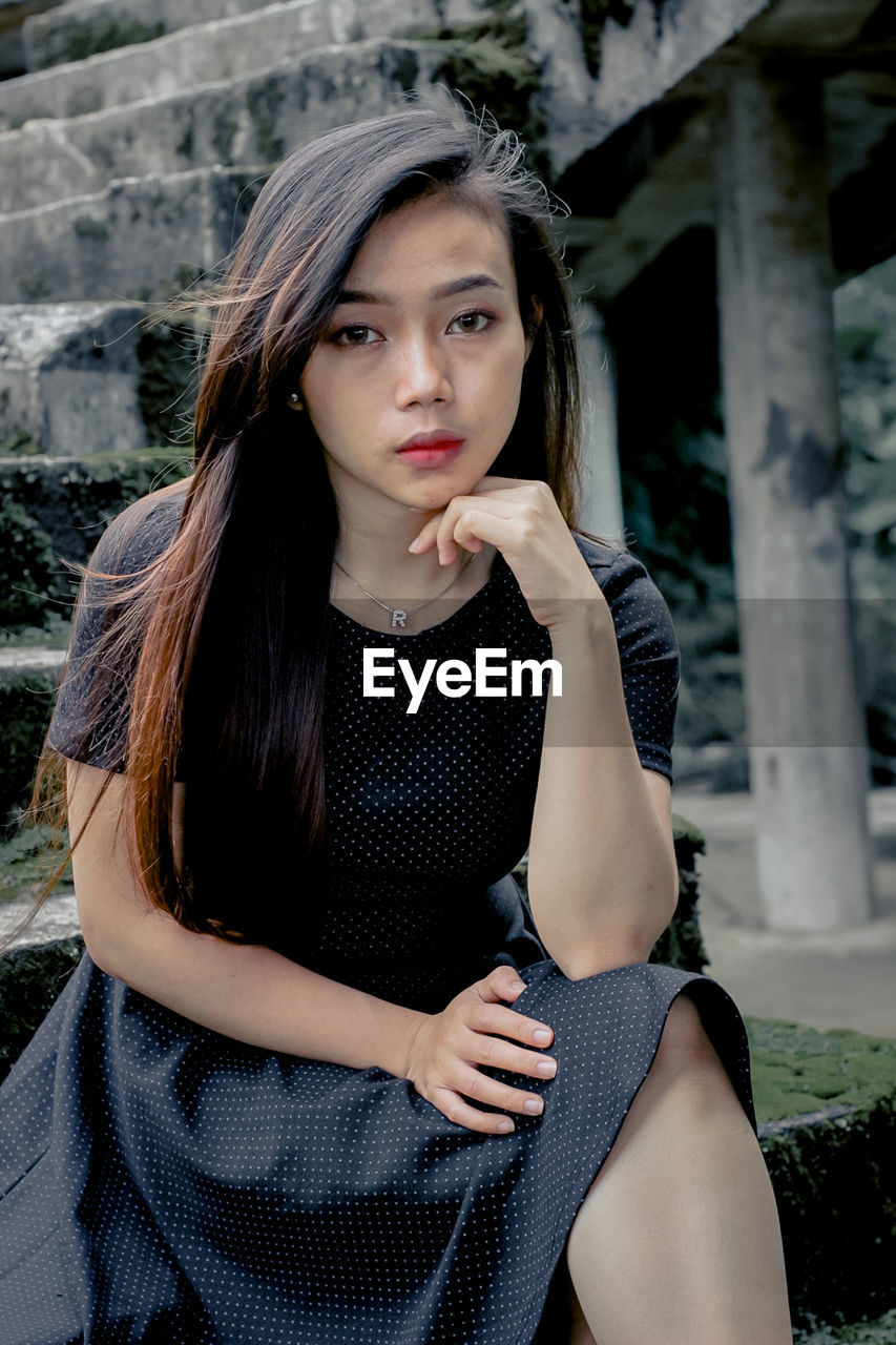 Portrait of young woman sitting outdoors