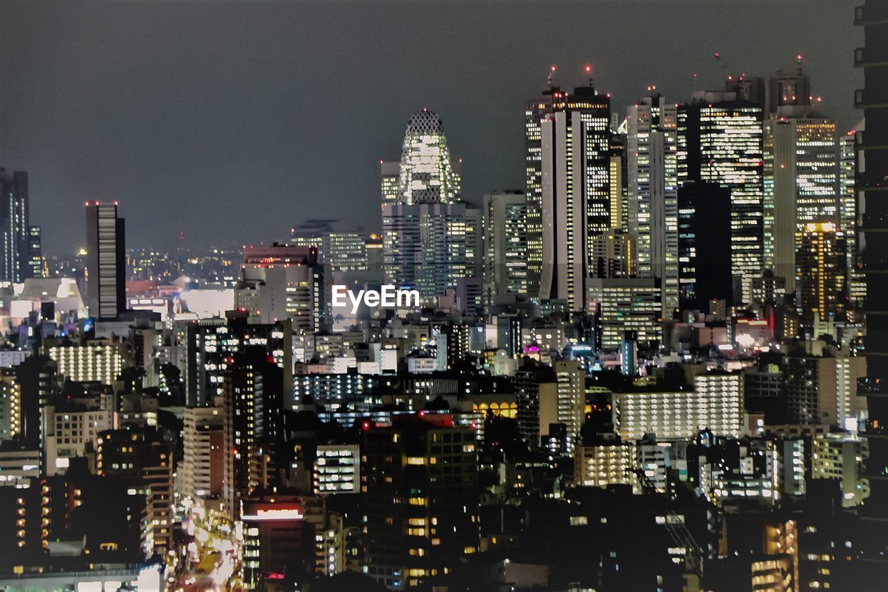 Illuminated cityscape against sky at night