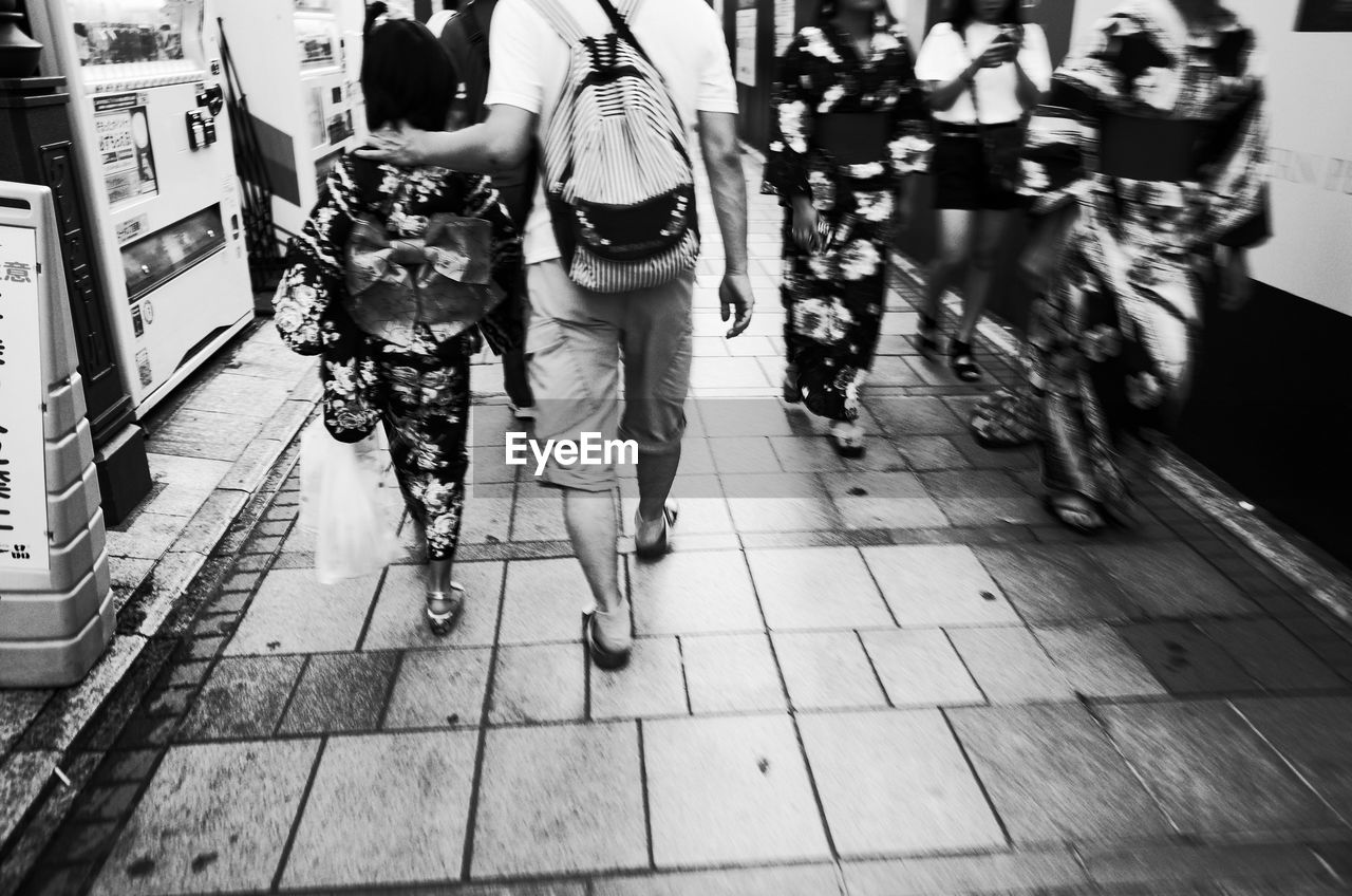 REAR VIEW OF WOMEN WALKING ON STREET