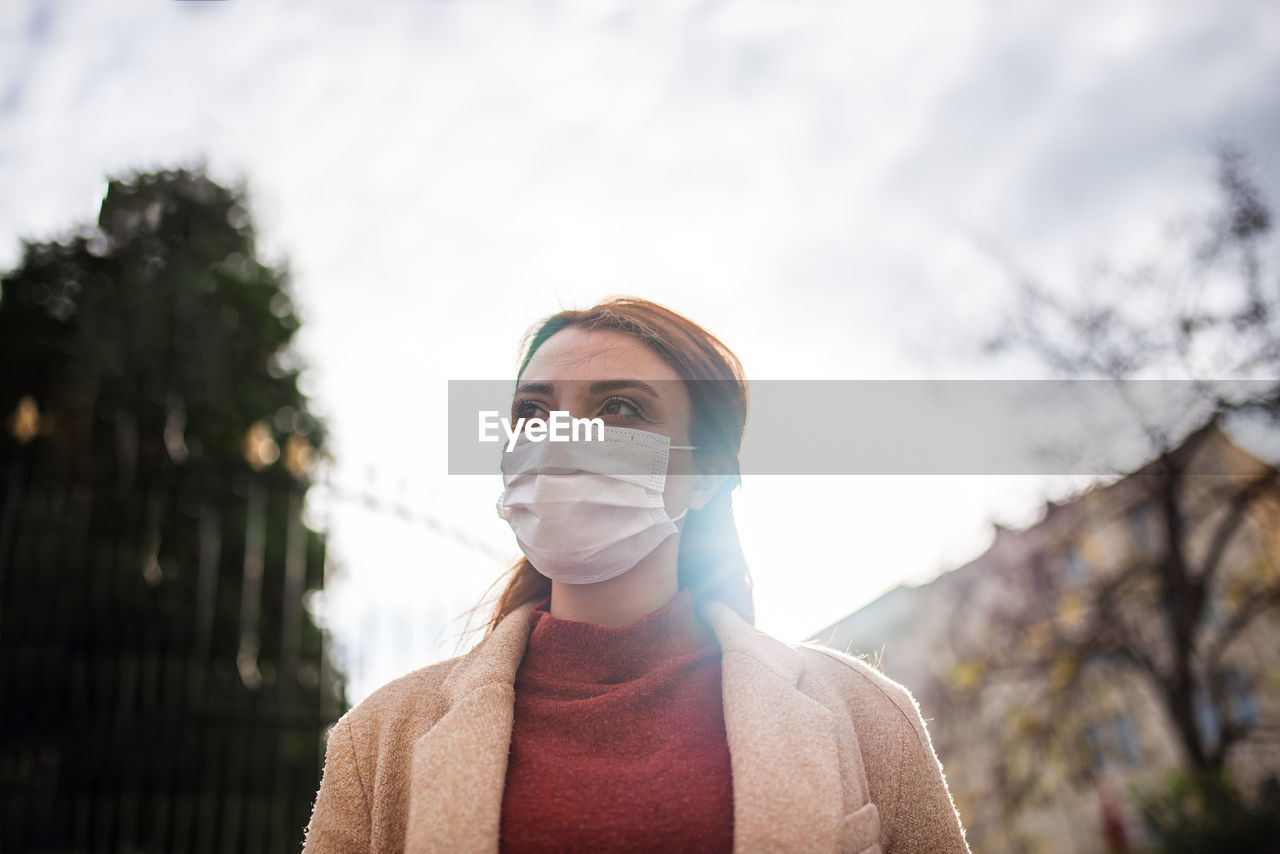 Portrait of woman standing against sky