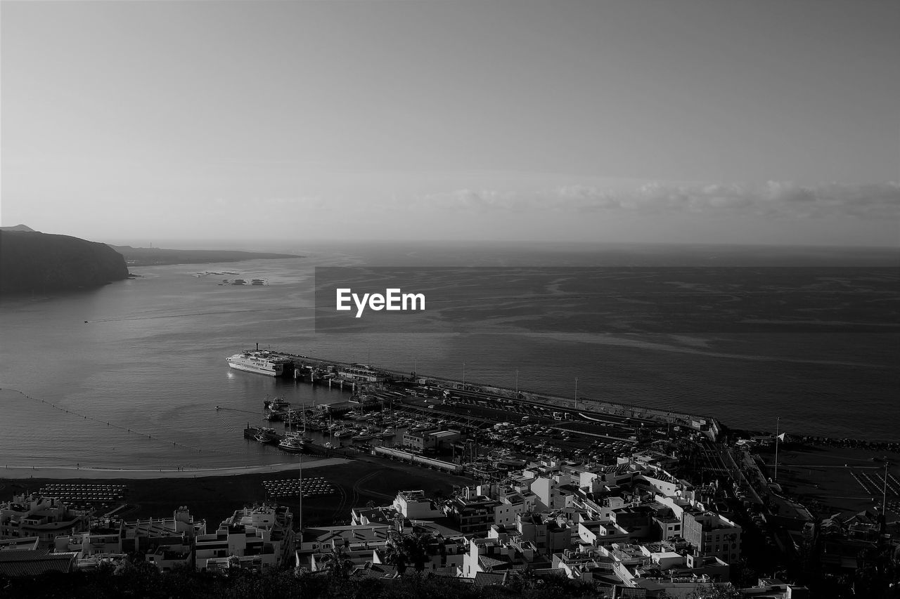 High angle view of townscape by sea against sky