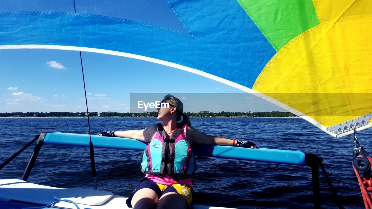 Woman looking away while sitting in boat on sea