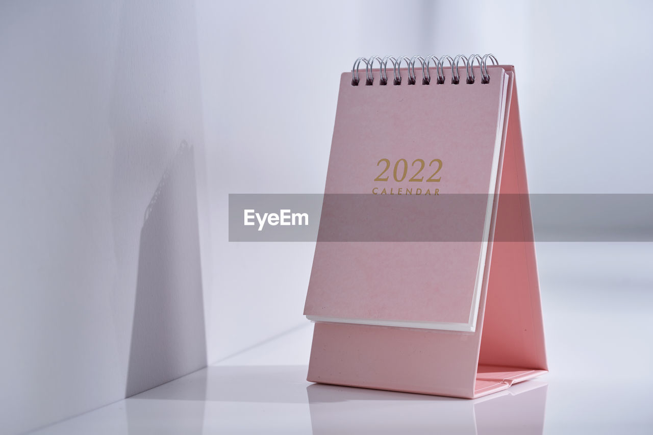 Pink desk 2022 calendar on table top near window