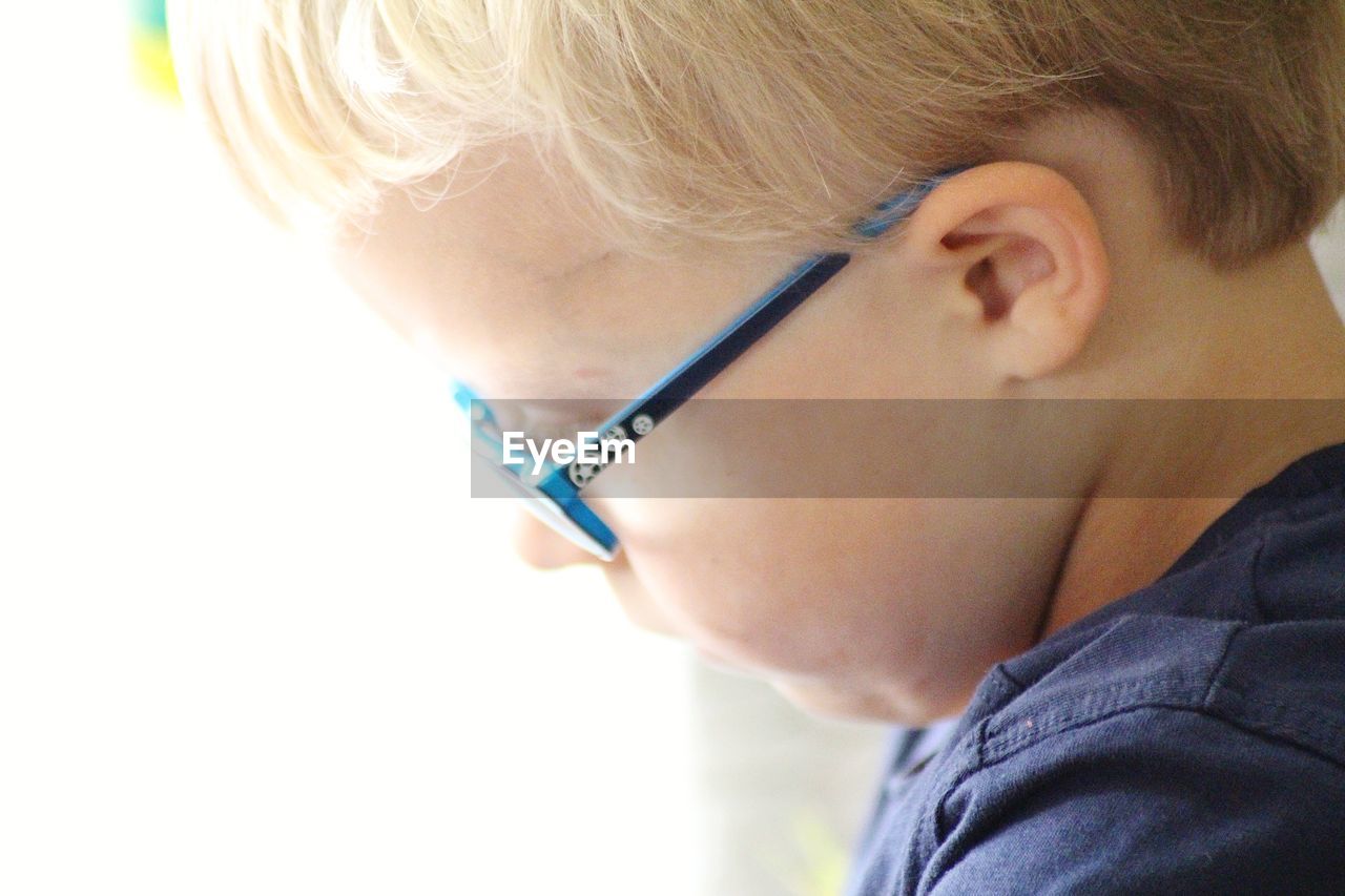 Close-up portrait of boy with glasses looking away