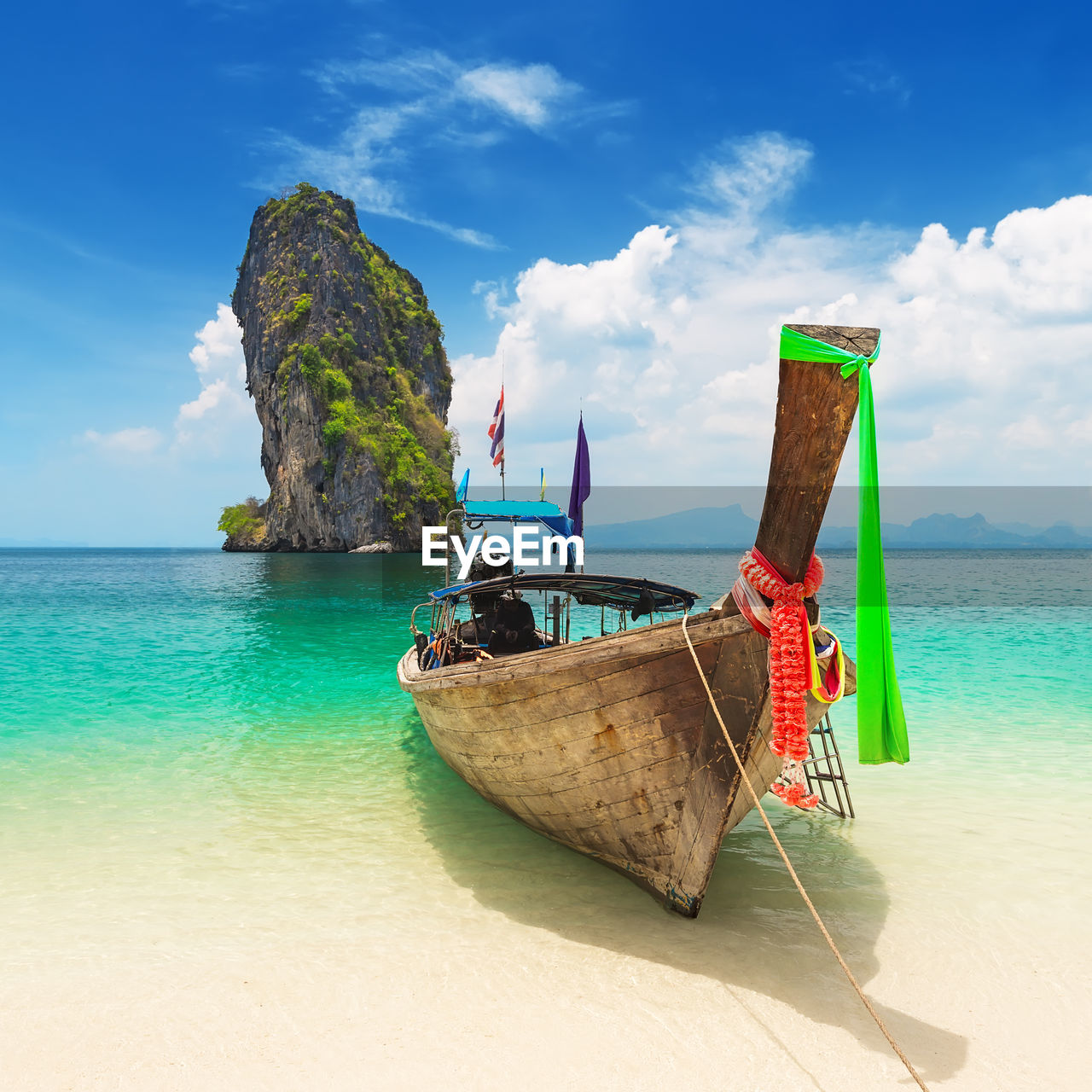 Thai traditional wooden longtail boat and sand beach at koh poda in krabi province, thailand.