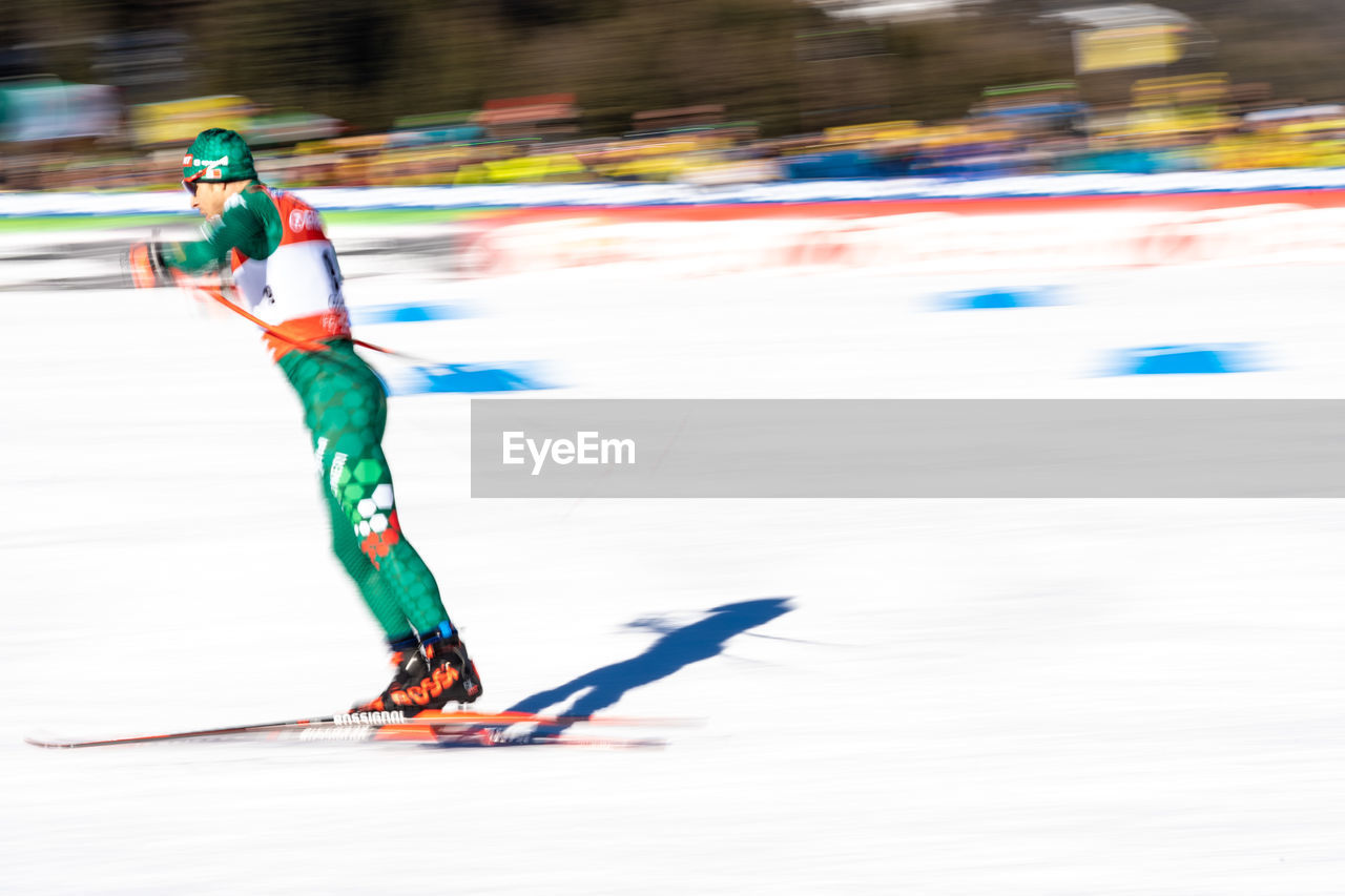 FULL LENGTH OF PERSON SKIING ON SNOW IN SNOWY FIELD