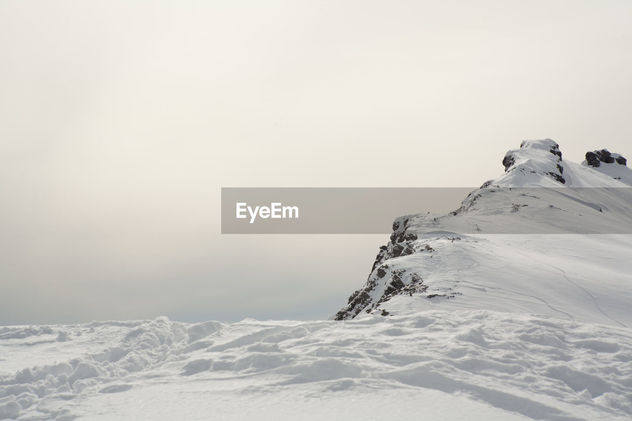 Low angle view of snowcapped mountain against clear sky