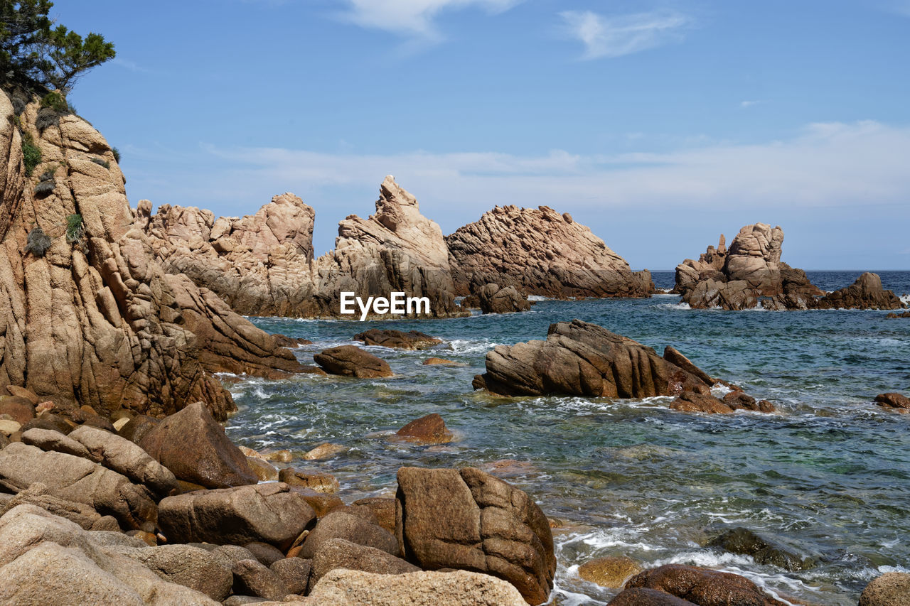 Rocks at beach against sky