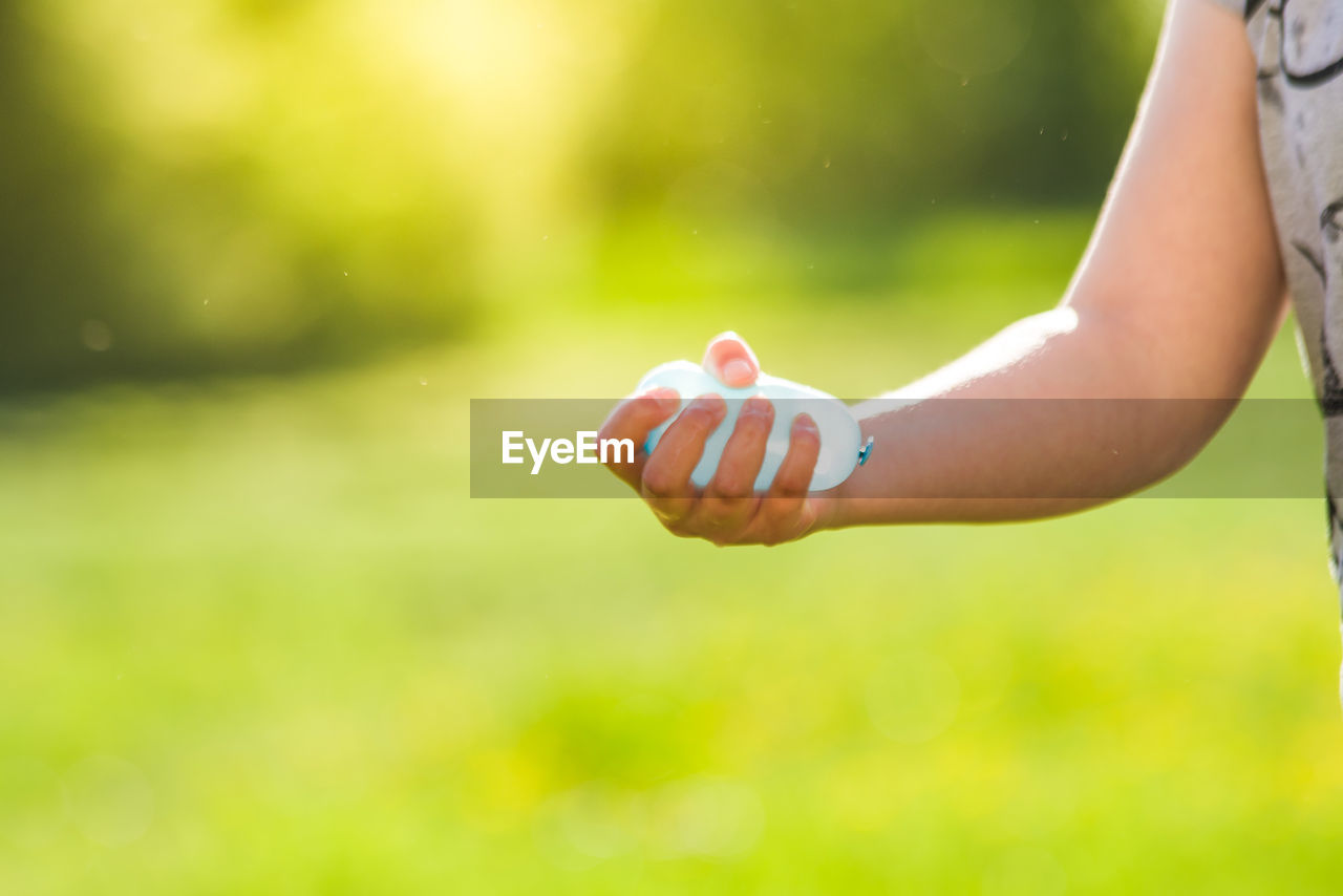 Cropped hand of woman holding balloon