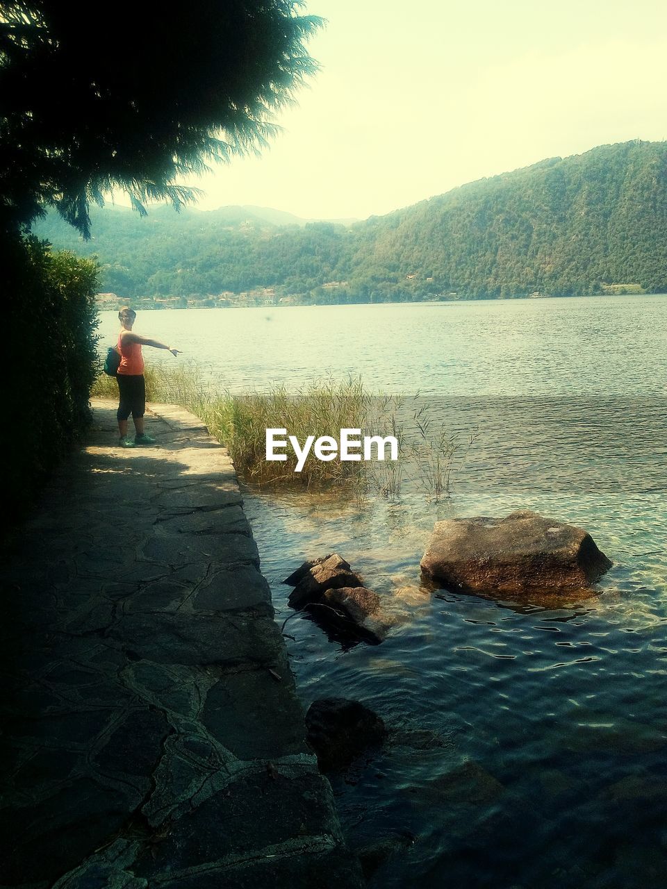 REAR VIEW OF MAN STANDING BY SEA