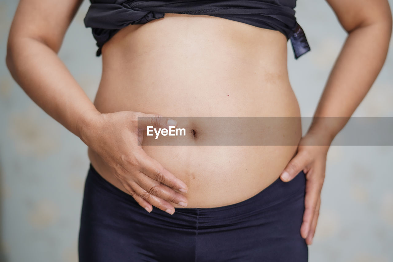 Midsection of woman standing against blurred background