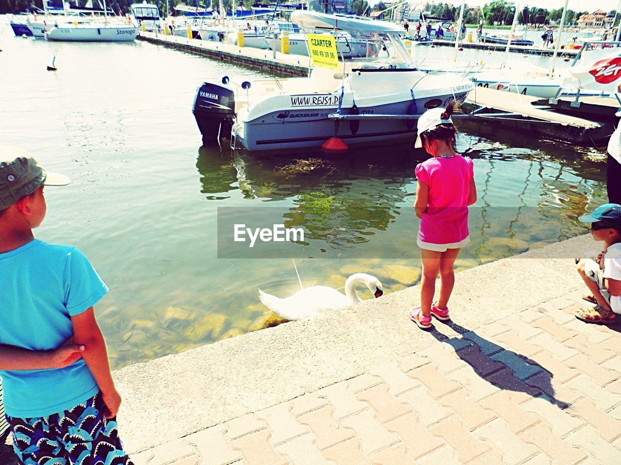 REAR VIEW OF PEOPLE WALKING ON WATER AT SHORE