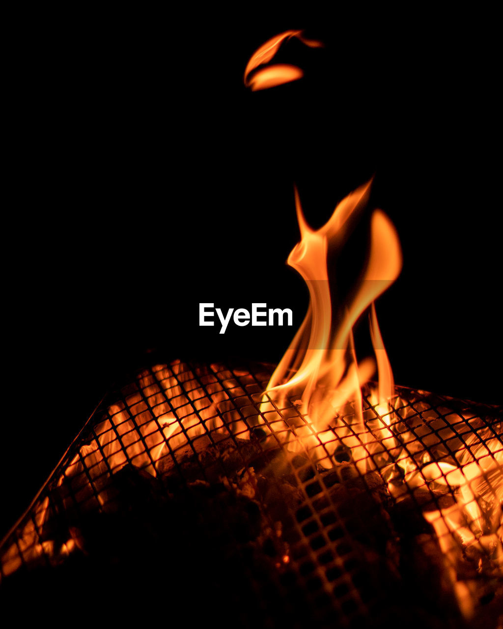 Close-up of fire on barbecue grill at night