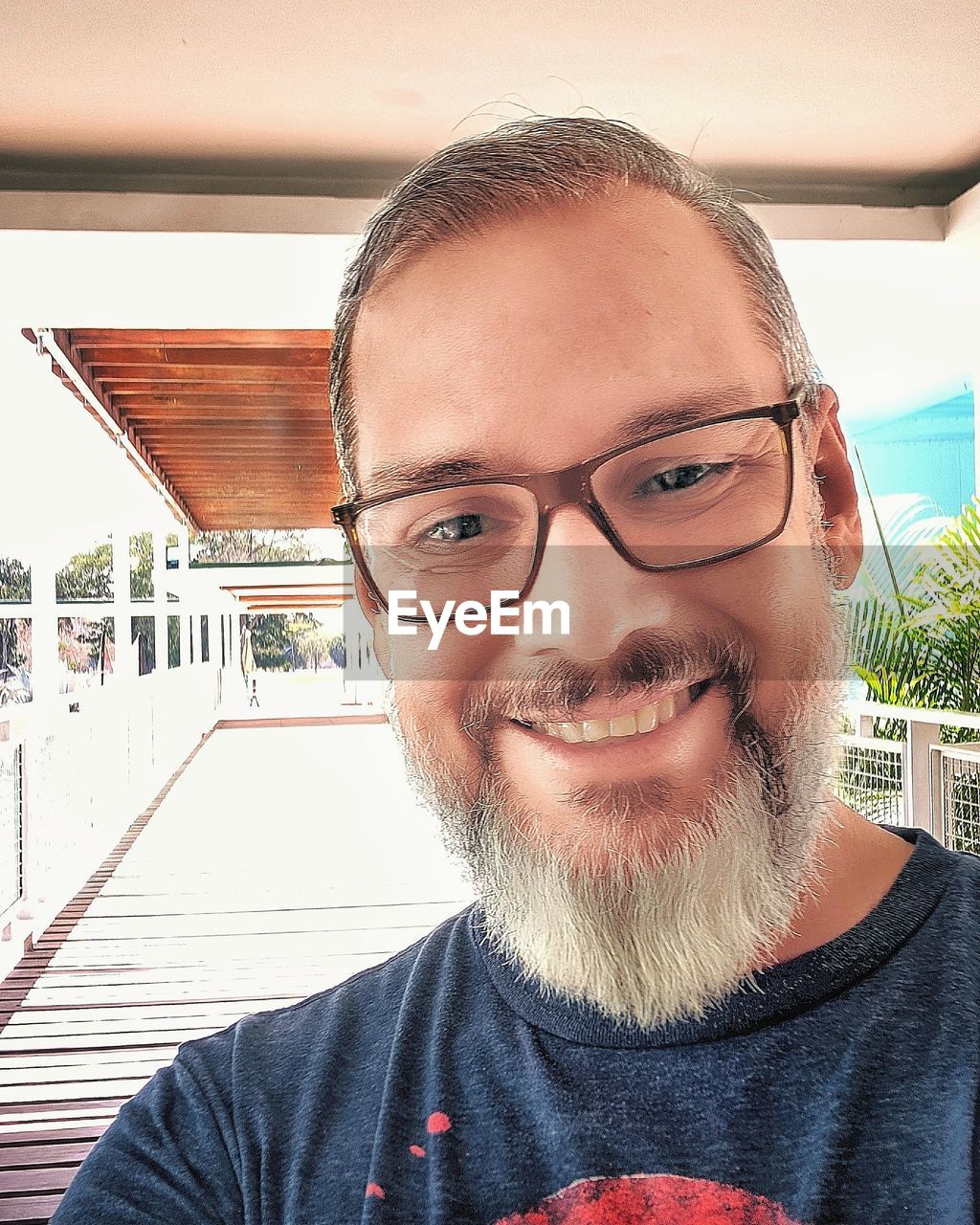 CLOSE-UP PORTRAIT OF SMILING YOUNG MAN WEARING EYEGLASSES