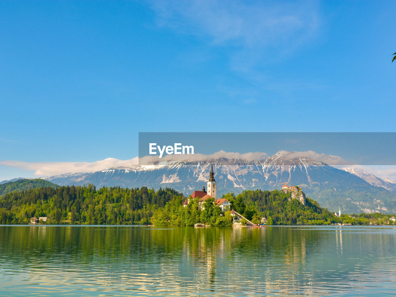 Scenic view of lake and mountains against blue sky