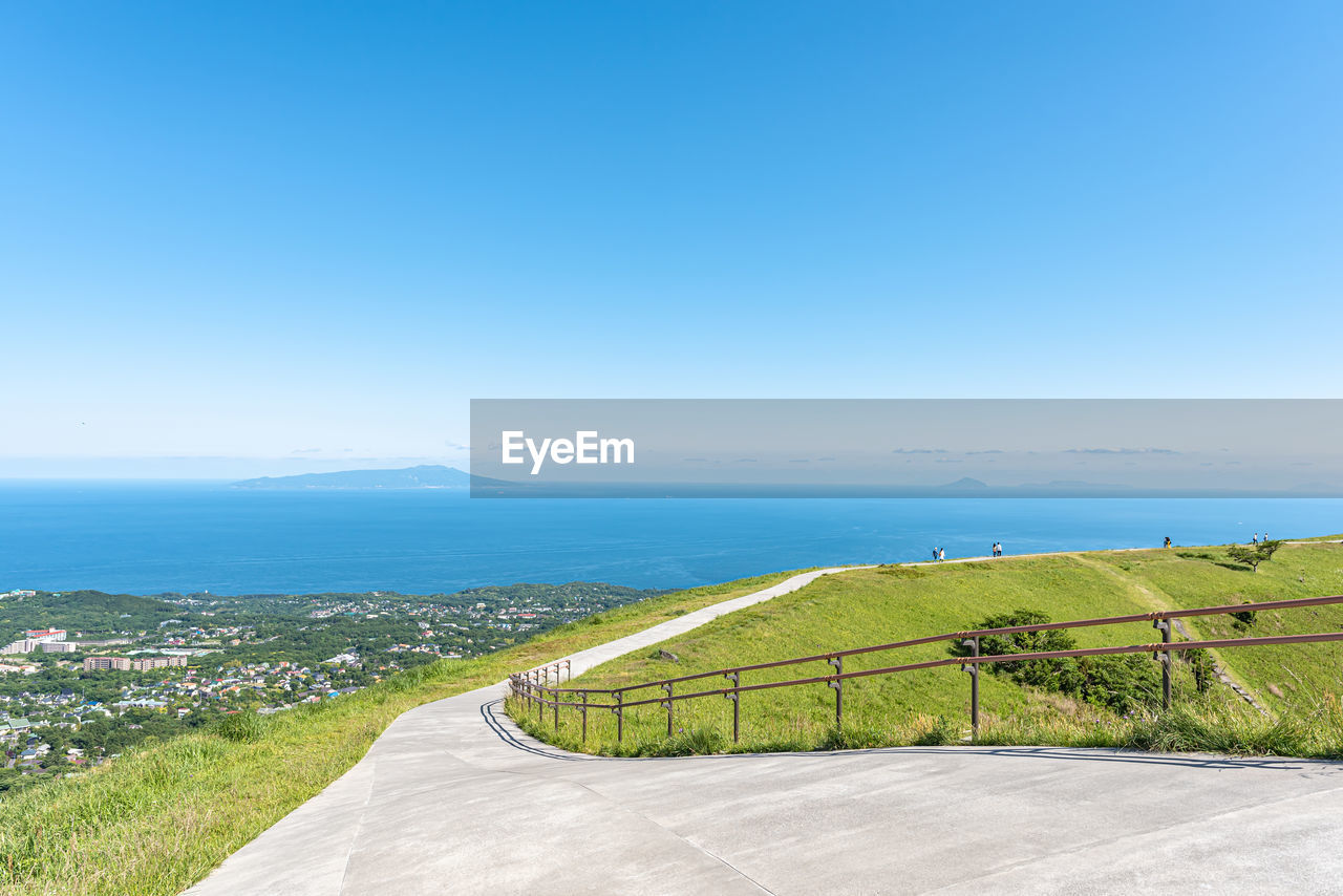 road by sea against clear blue sky