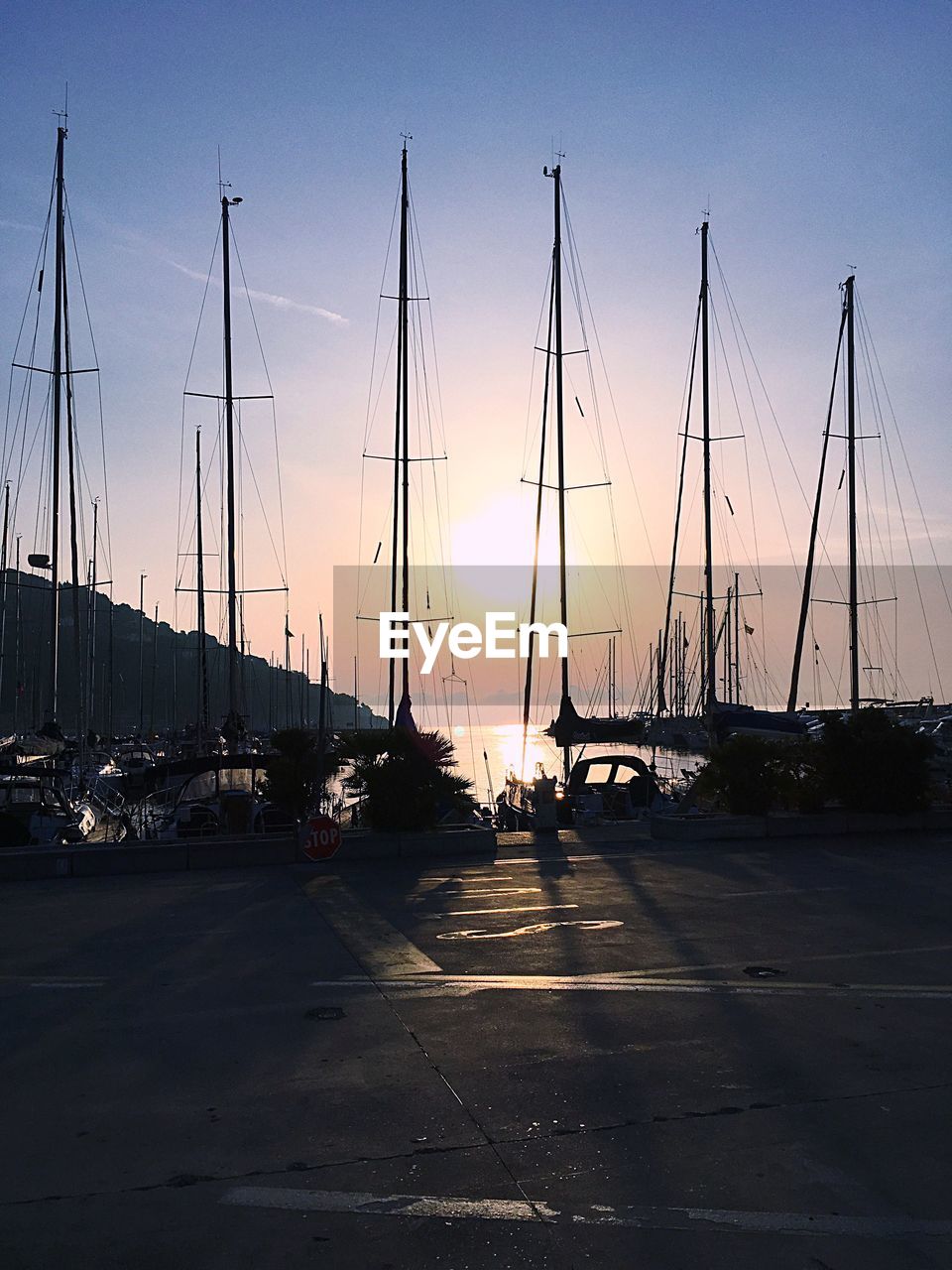 SAILBOATS MOORED AT HARBOR AGAINST SKY