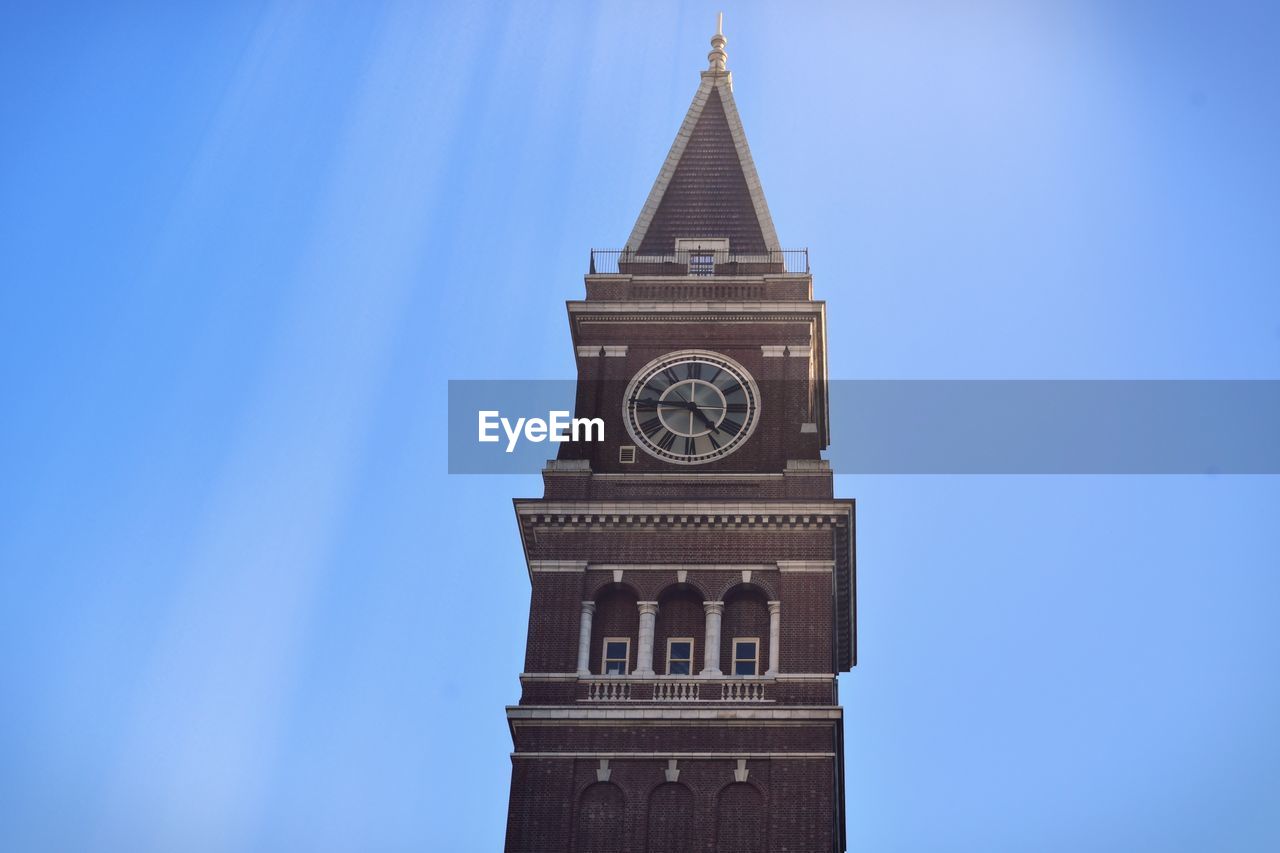 Low angle view of clock tower against blue sky