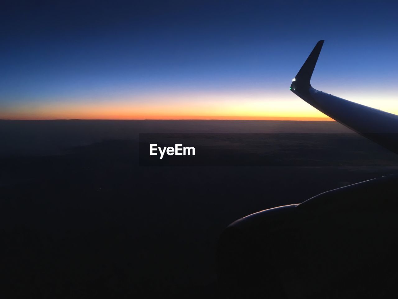 SILHOUETTE AIRPLANE WING AGAINST CLEAR SKY