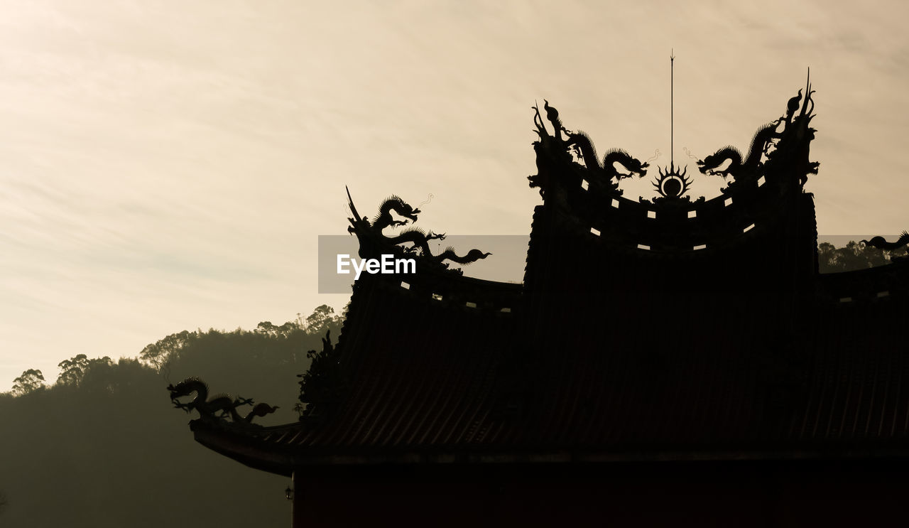 Low angle view of silhouette temple against sky