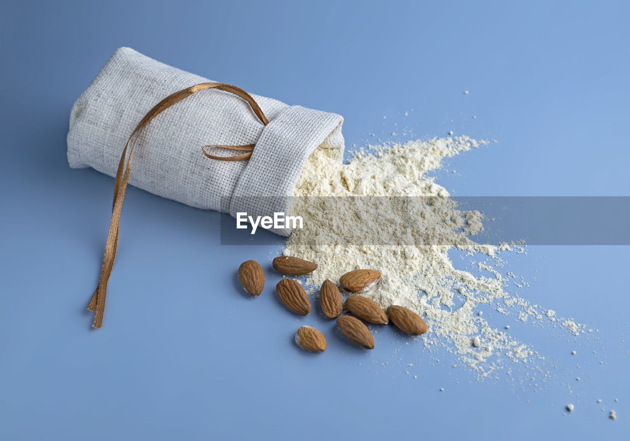 Almond flour, bag of nut flour on blue background