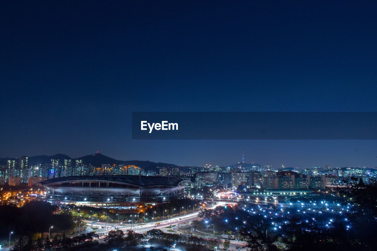 Aerial view of illuminated cityscape against sky at night