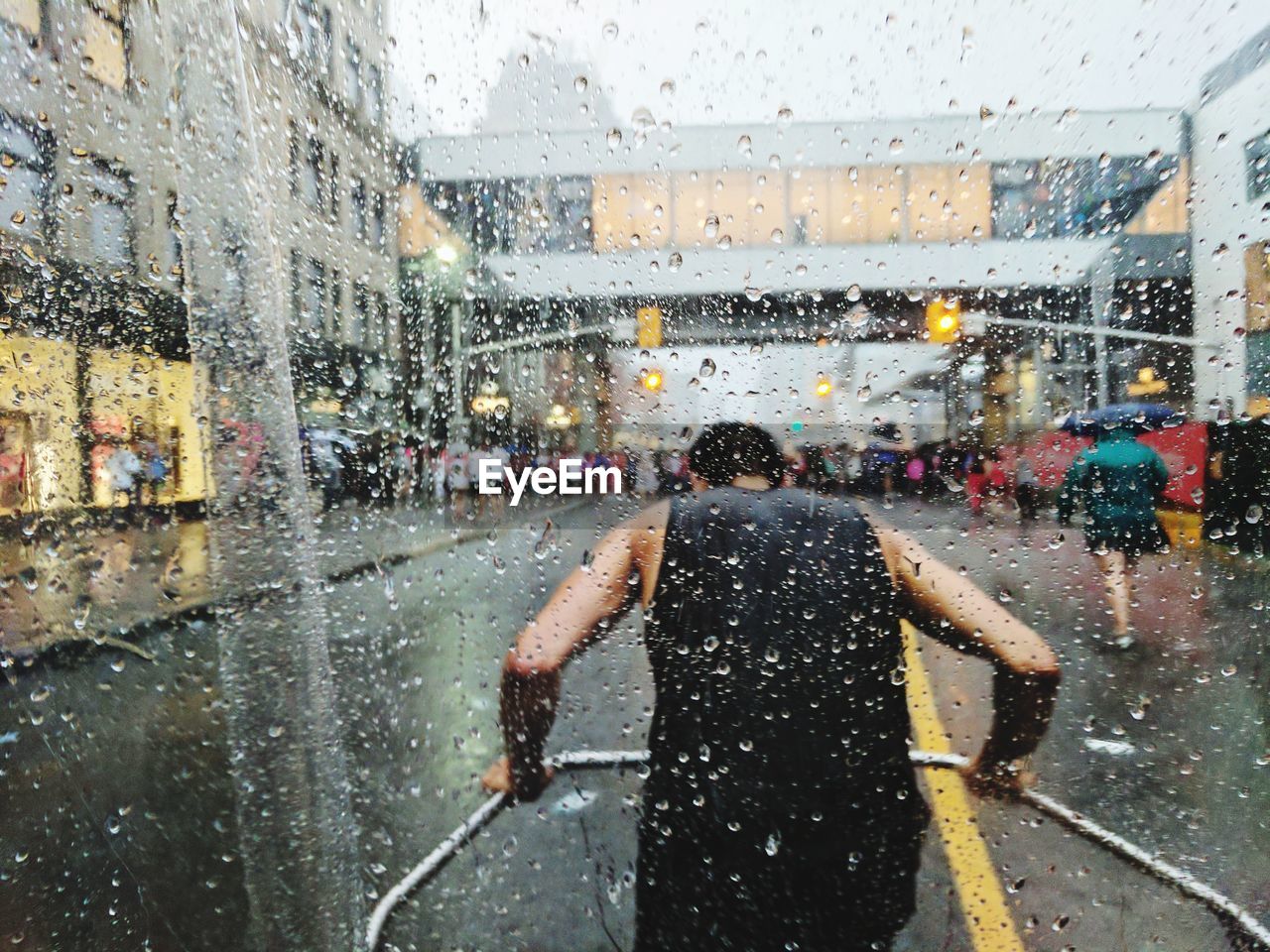 People on wet street in city during rainy season