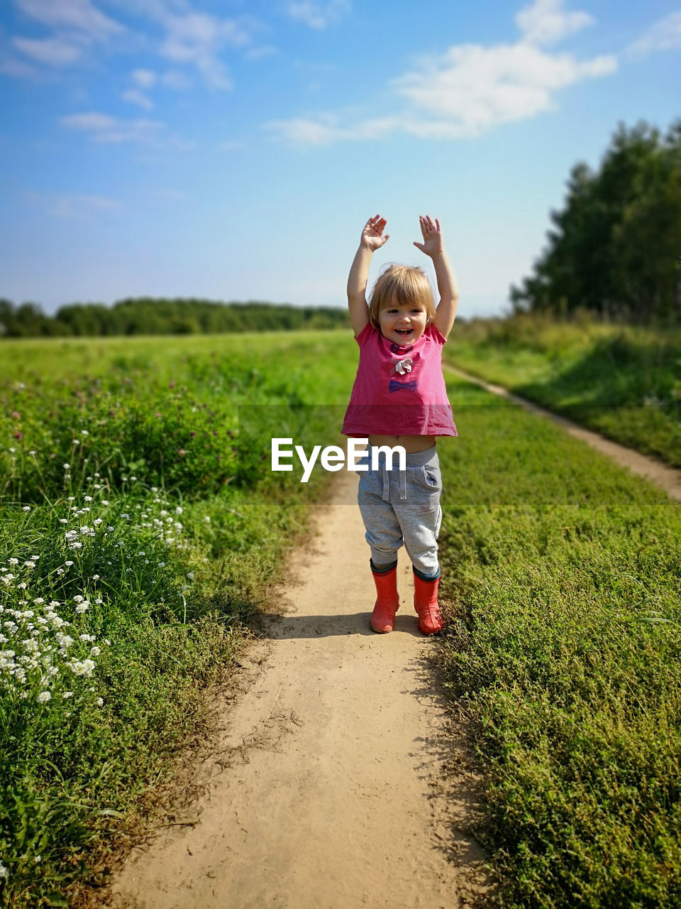 Full length of girl standing on field against sky