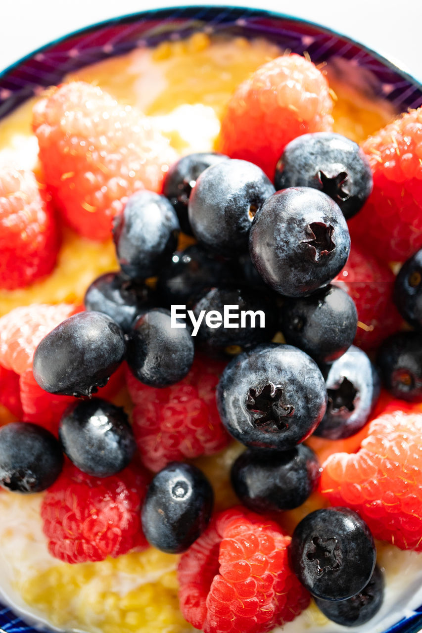 CLOSE-UP OF RASPBERRIES IN PLATE