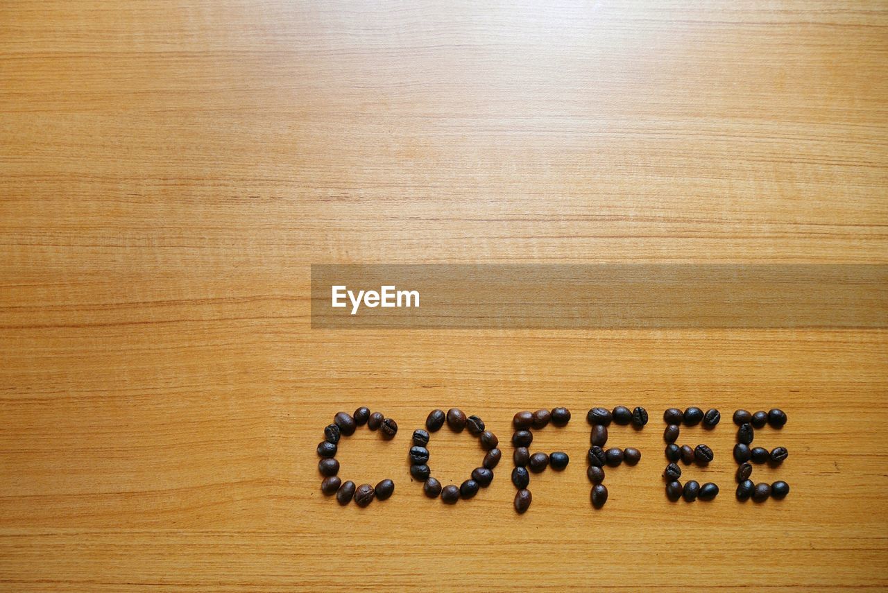 HIGH ANGLE VIEW OF COFFEE WITH TEXT ON TABLE