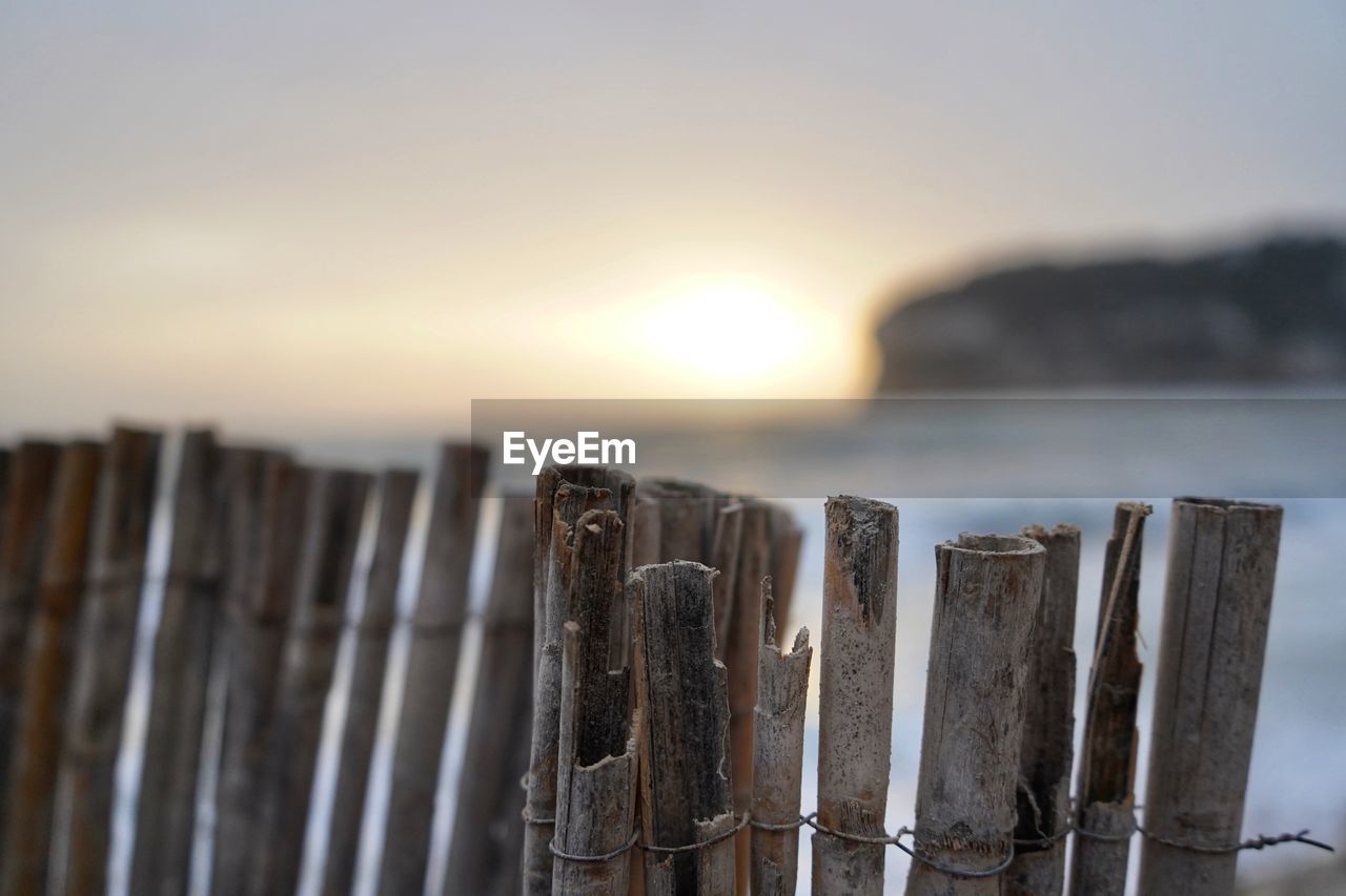 Close-up of wooden fence against sky during sunset