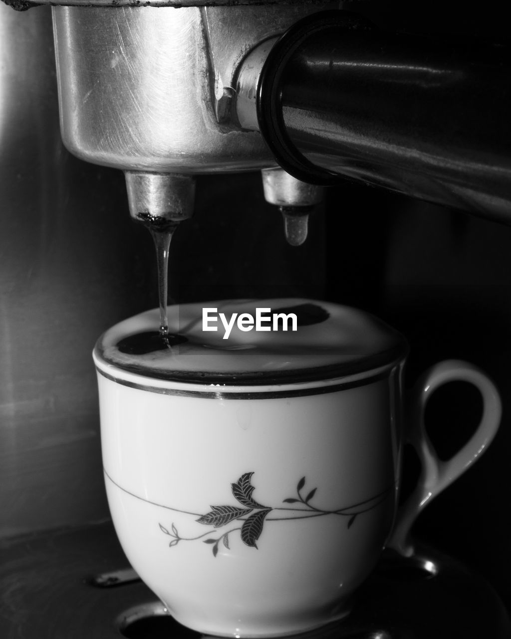 coffee, cup, food and drink, drink, coffee cup, indoors, mug, small appliance, refreshment, hot drink, home appliance, espresso machine, black and white, coffeemaker, tableware, close-up, food, no people, still life photography, pouring, kitchen appliance, appliance, monochrome photography