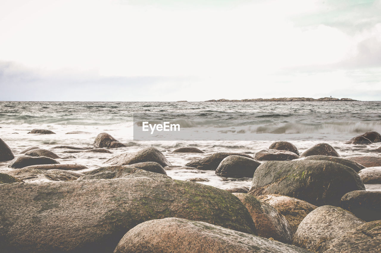 Rocks on beach against sky