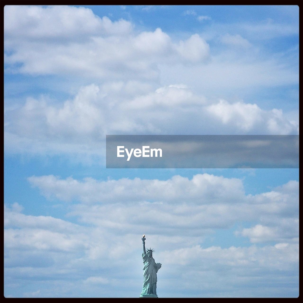 Statue of liberty against clouds at new york city