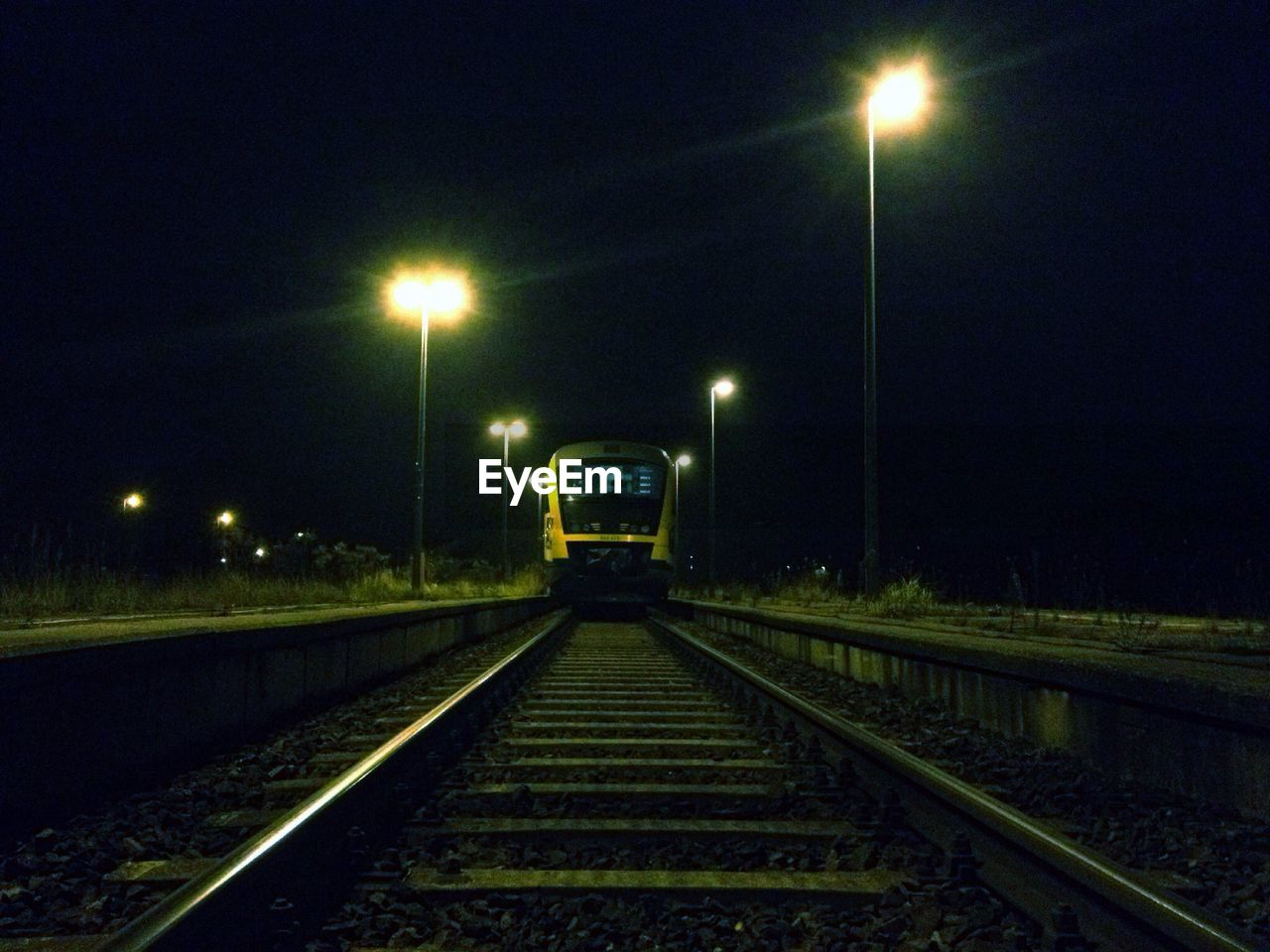 Train on railroad track at station during night